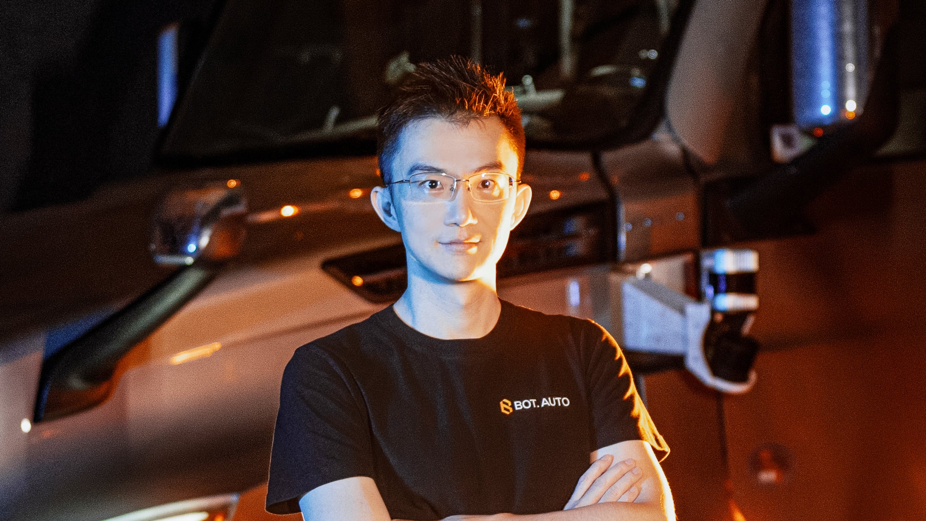 Xiaodi Hou standing in front of a truck