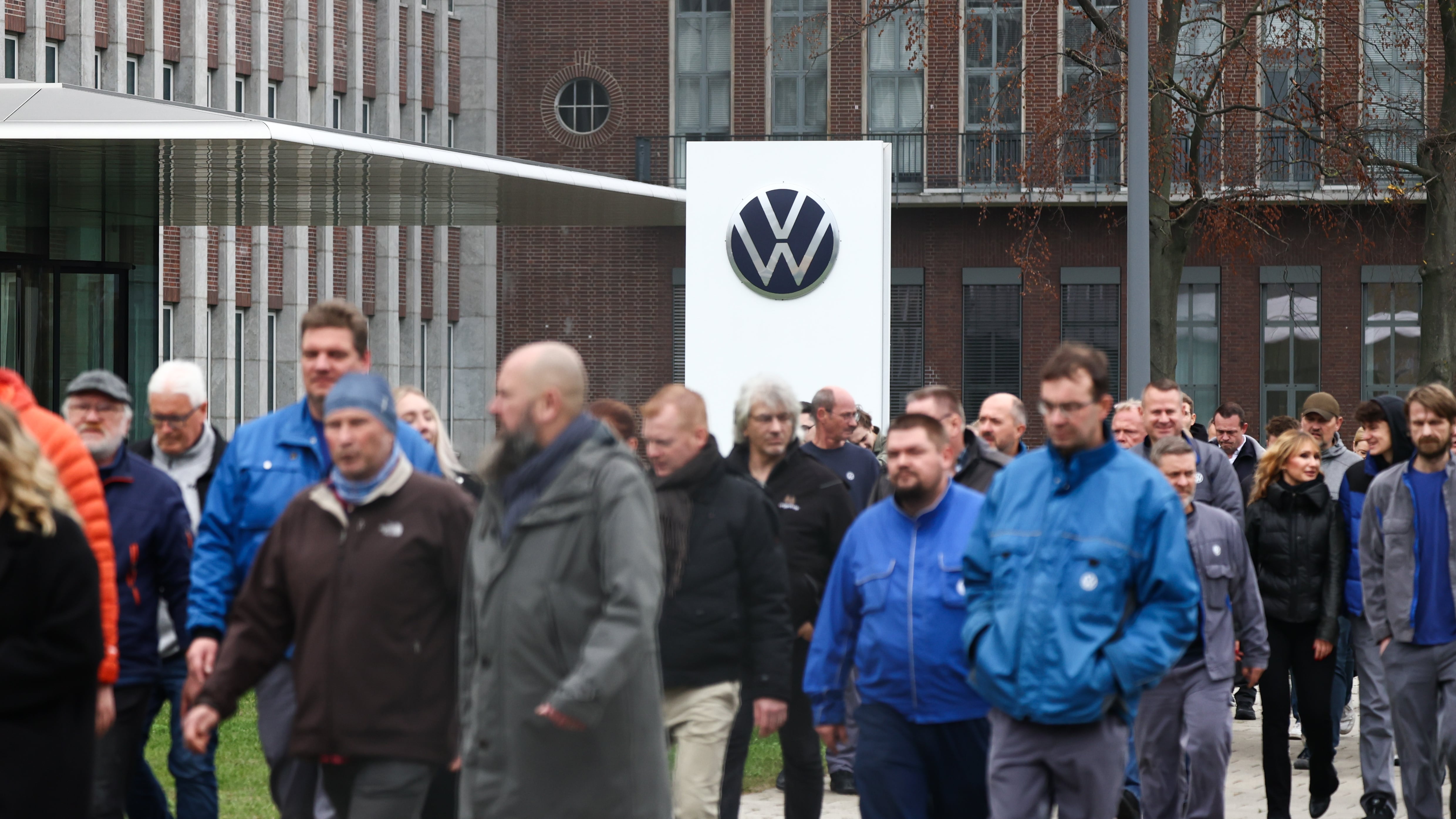 VW workers walking past a VW sign during a rally at the company's headquarters in Wolfsburg, Germany, on Oct. 28.