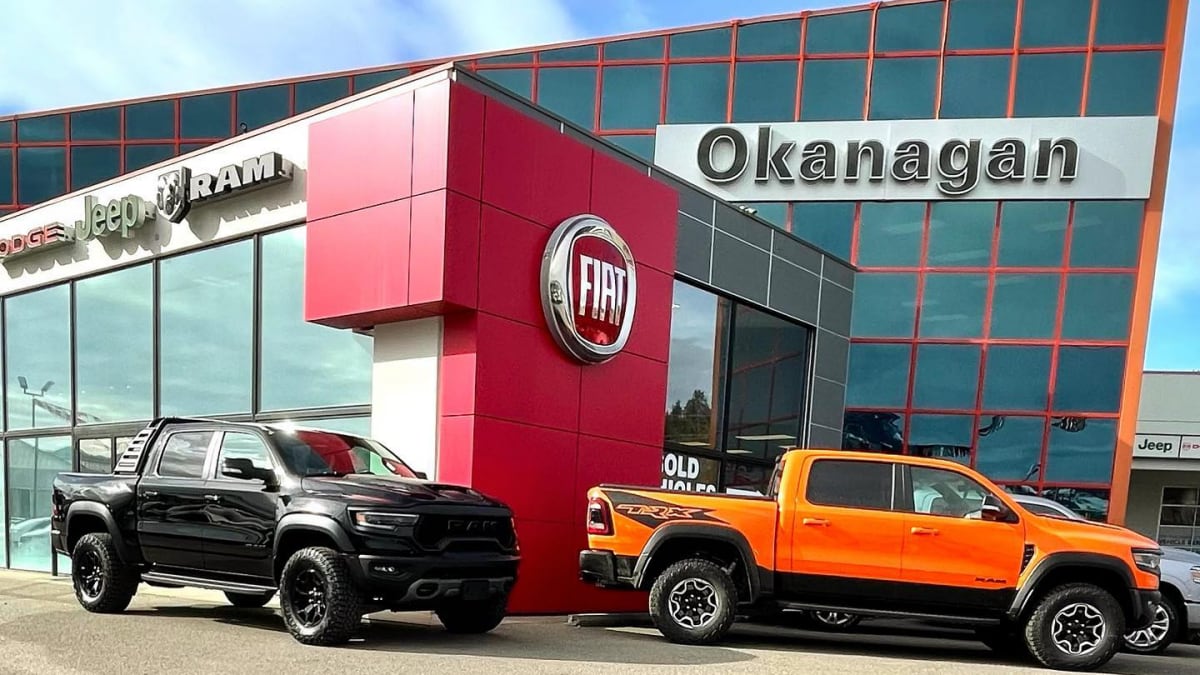 A photo of the exterior of Okanagan Chrysler-Dodge-Jeep-Ram with two Ram pickups out front.